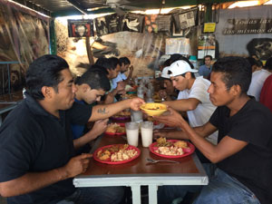 Recently deported immigrants share a meal.